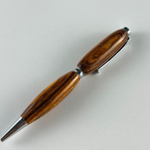 Handcrafted Desert Ironwood twist-action ballpoint pen with polished silver-tone accents